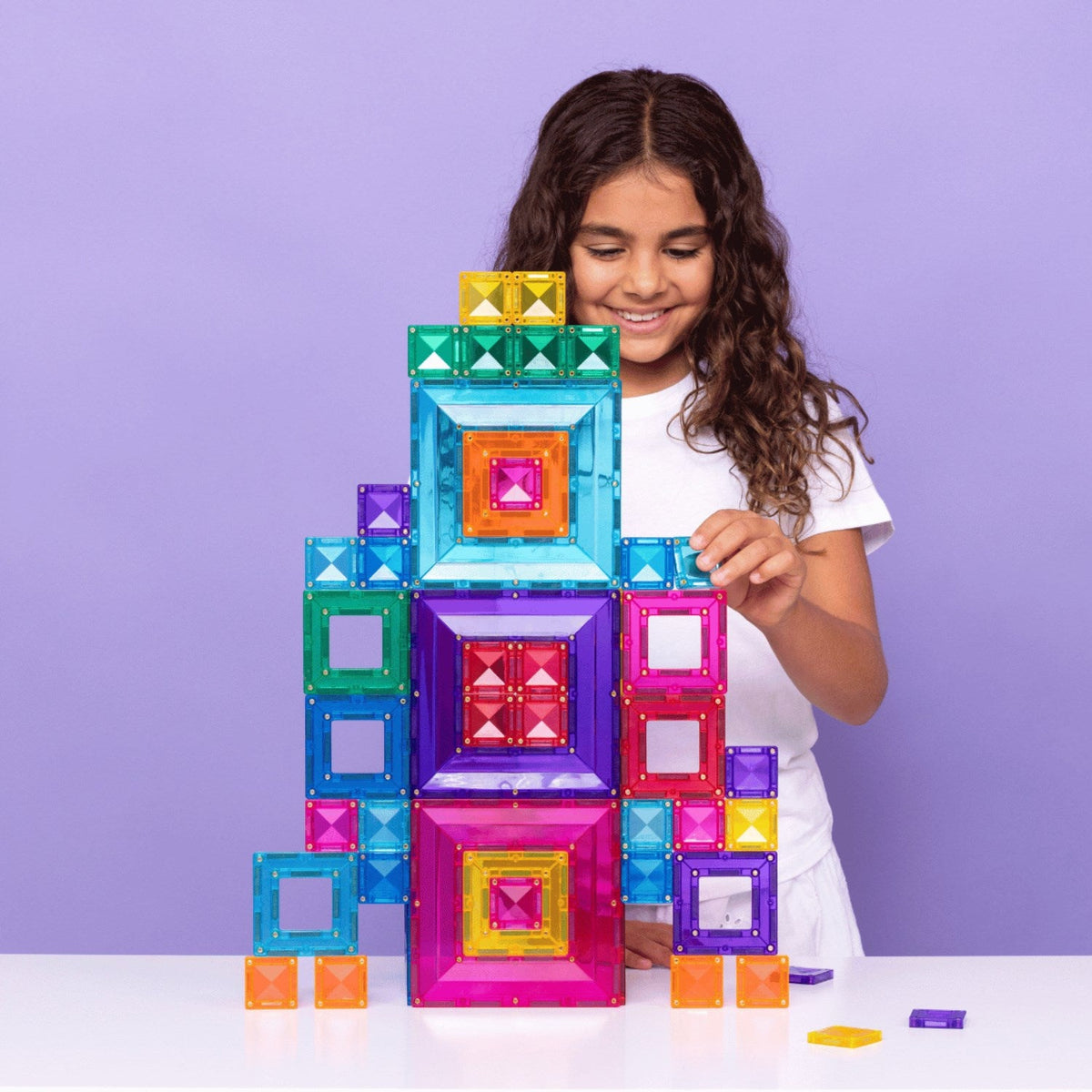 Pige der leger med Magna Tiles og Connetix sammen